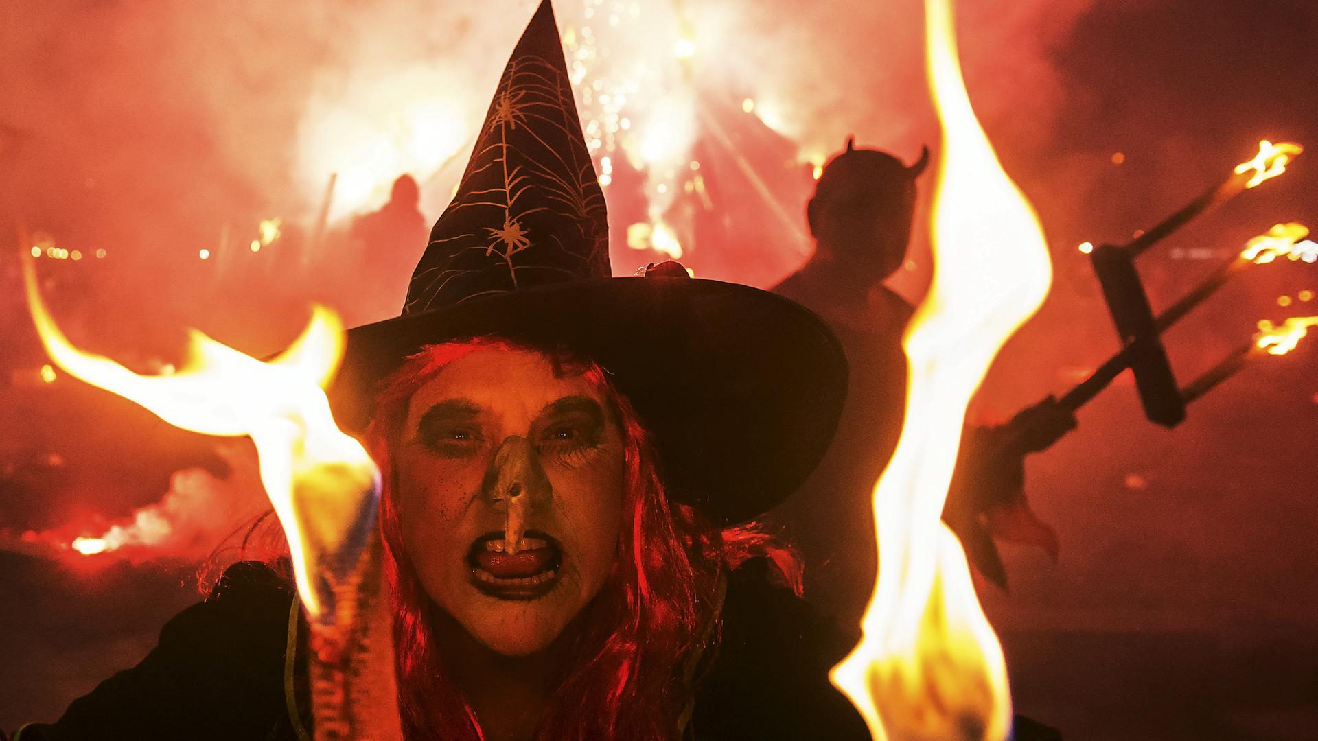 Als Teufel (rechts) und Hexe (Mitte) verkleidete Menschen treten während der Walpurgisnacht in Erfurt auf. 