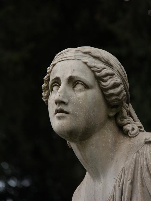 Eine leidende weibliche Steinfigur auf einem Friedhof.