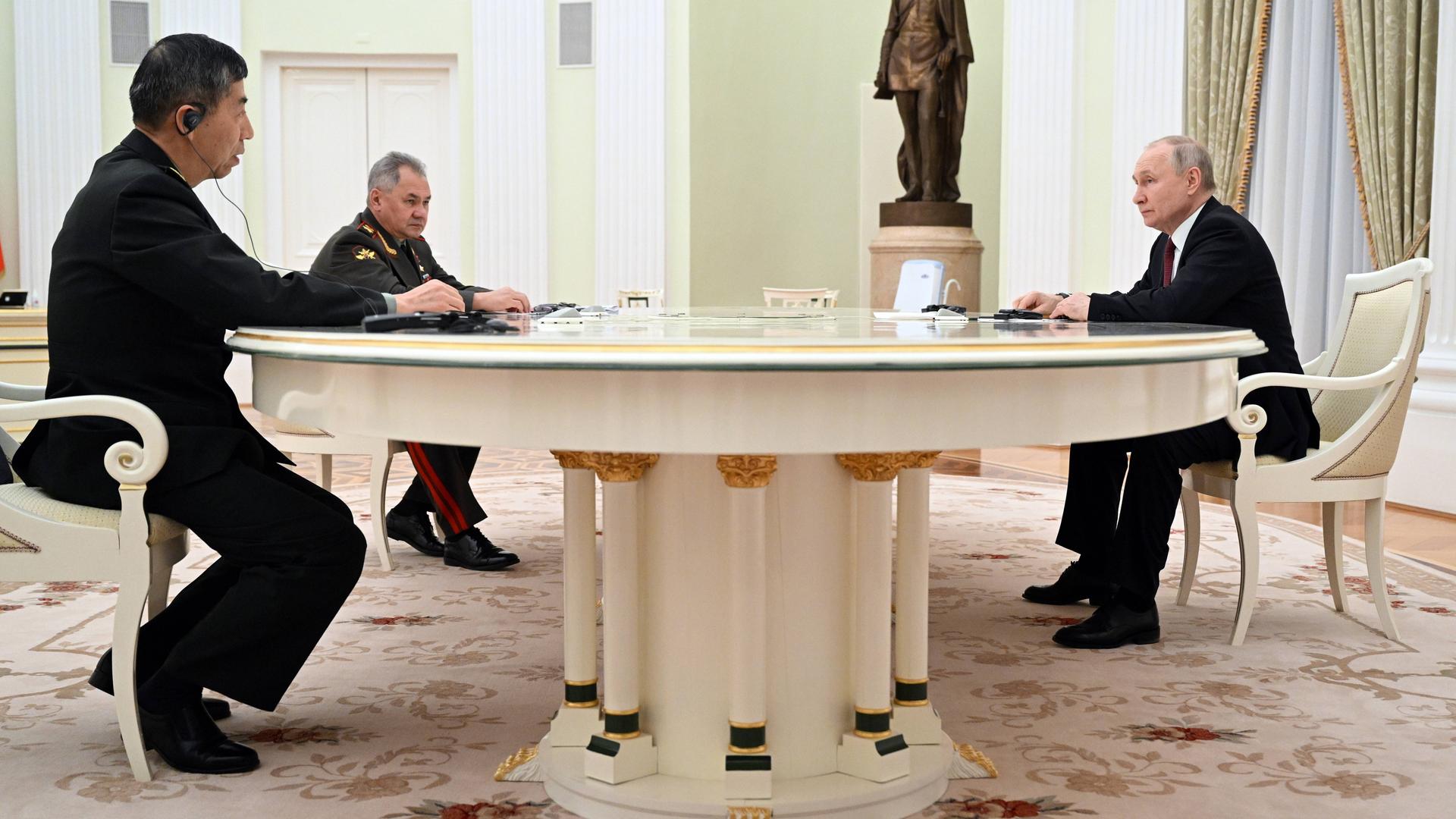 Der chinesische Verteidigungsminister Li Shangfu (links) sitzt am Tisch mit Russland Präsident Putin in Moskau.