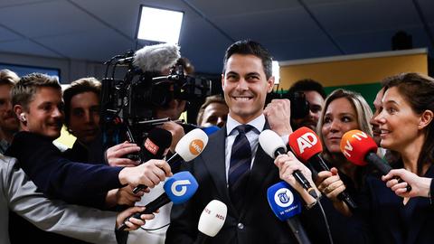 Ein Mann wird von Journalisten umringt.