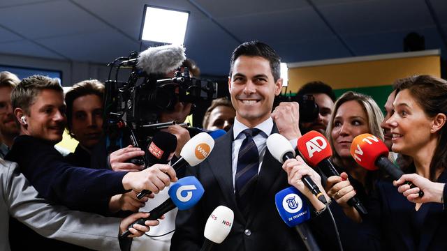 Ein Mann wird von Journalisten umringt.