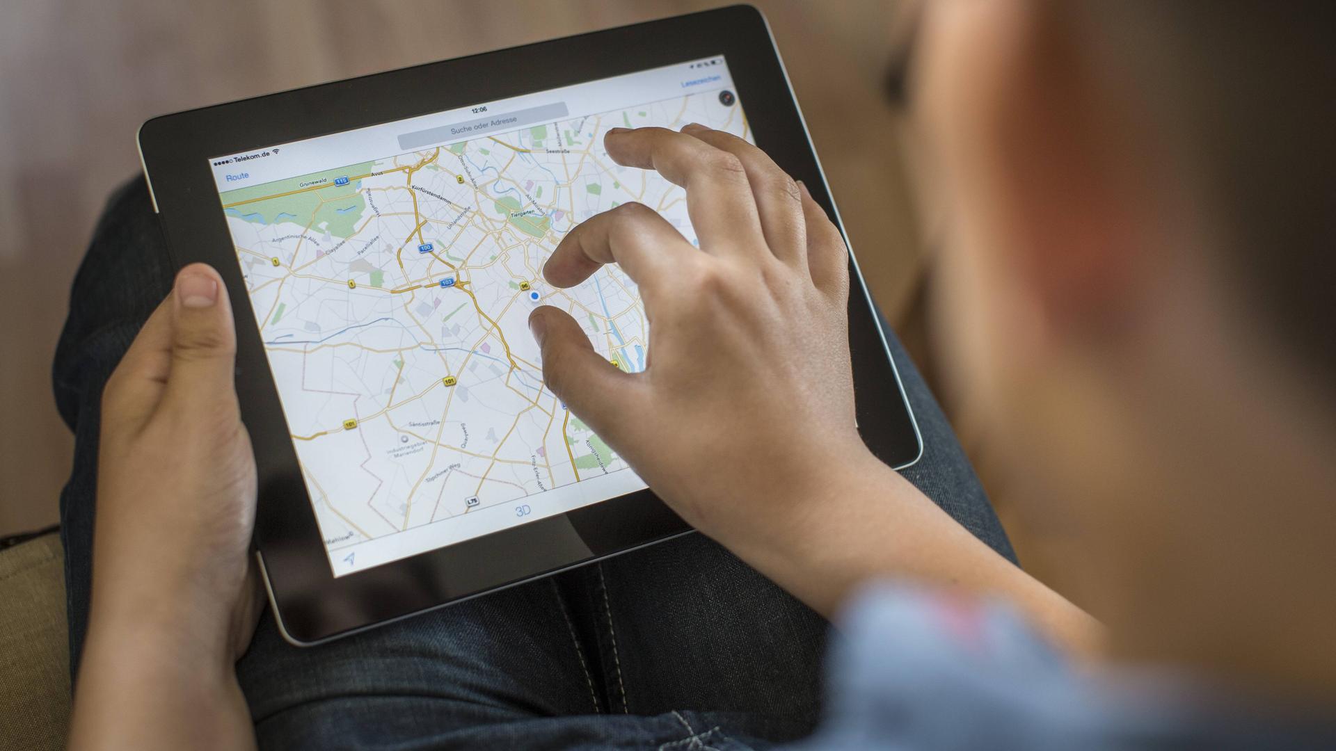 Ein Mann betrachtet seinen Standort auf Google Maps mit einem Tablet. Ein Mann betrachtet seinen Standort auf Google Maps mit einem Tablet.