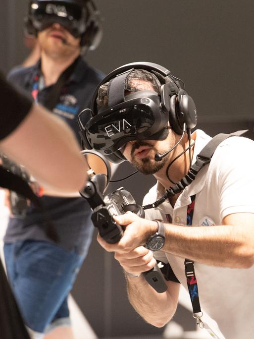 Besucher spielen ein virtuelles Ego-Shooter-Spiel auf der Messe Gamescom in Köln 2023. Besucher spielen ein virtuelles Ego-Shooter-Spiel auf der Messe Gamescom in Köln 2023.
