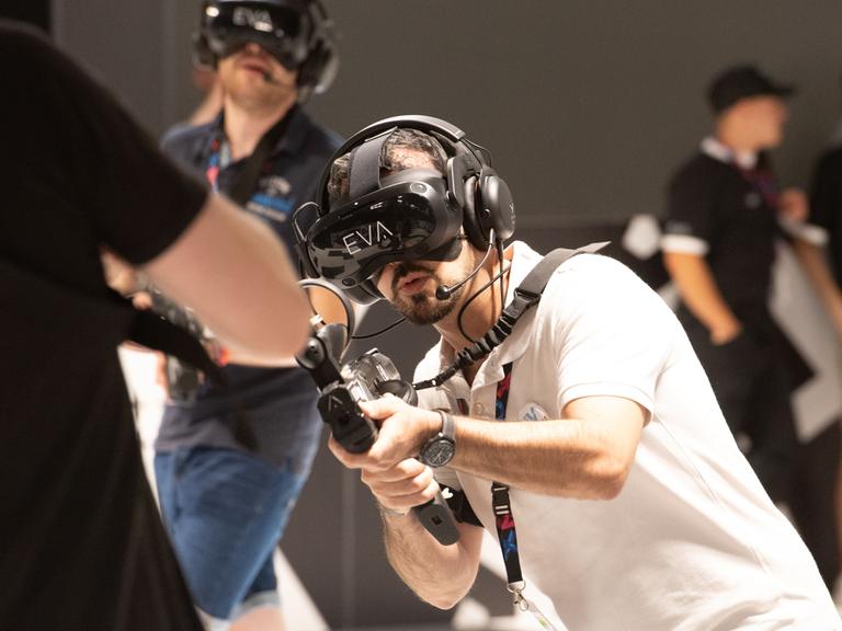 Besucher spielen ein virtuelles Ego-Shooter-Spiel auf der Messe Gamescom in Köln 2023. Besucher spielen ein virtuelles Ego-Shooter-Spiel auf der Messe Gamescom in Köln 2023.