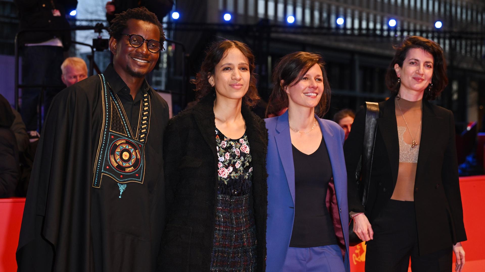Protagonist Gildas Adannou, Regisseurin und Produzentin Mati Diop und die Produzentinnen Eve Robin und Judith Lou Lévy des Films "Dahomey" gehen über den Roten Teppich zur Preisverleihung bei der Abschlussgala im Berlinale-Palast.