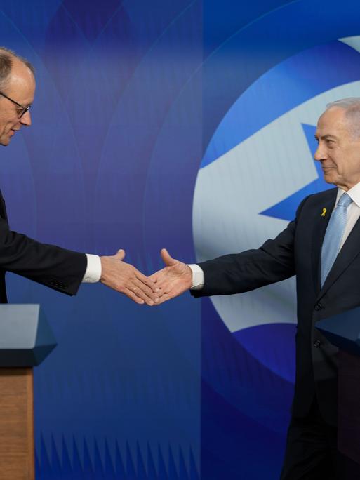 Bundeskanzler Friedrich Merz (l, CDU) schüttelt die Hand von Benjamin Netanjahu, Ministerpräsident von Israel. Im Hintergrund sieht man eine Flagge von Deutschland und eine von Israel. Bundeskanzler Friedrich Merz (l, CDU) schüttelt die Hand von Benjamin Netanjahu, Ministerpräsident von Israel. Im Hintergrund sieht man eine Flagge von Deutschland und eine von Israel.