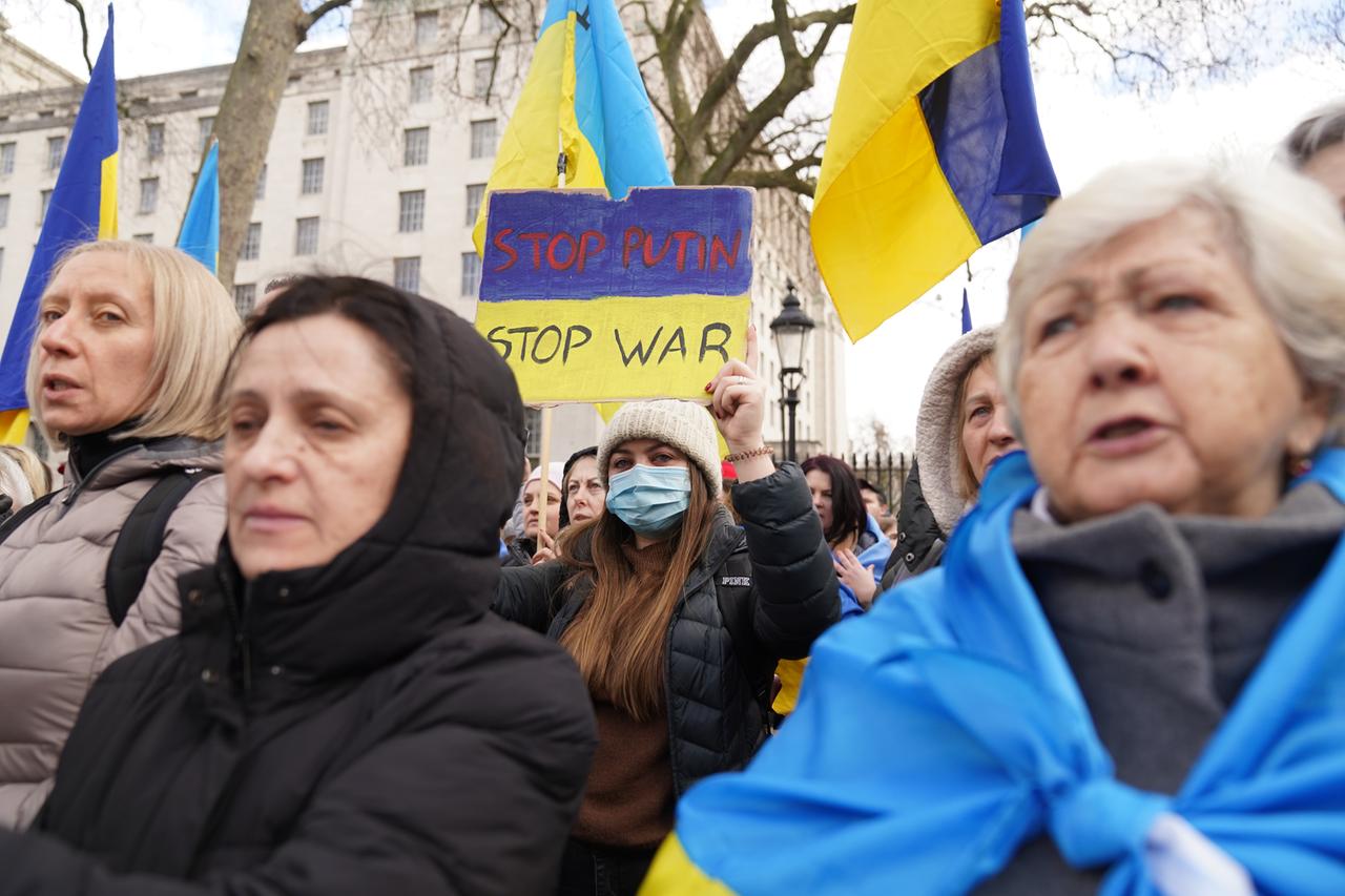 Demonstrantinnen halten Plakate mit der Aufschrift "Stoppt Putin" in die Höhe.