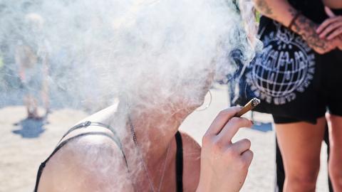 Eine Demonstrantin raucht einen Joint bei der Hanfparade. Ihr Gesicht ist hinter einer Rauchwolke verborgen. Die Hanfparade ist laut Angaben der Veranstalter die größte und traditionsreichste Demonstration für Cannabis in Deutschland.