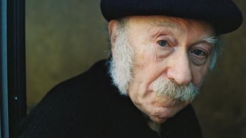 Edgar Hilsenrath schaut in die Kamera. Er hat einen weißen Schnauzer und trägt eine schwarze Baskenmütze. Edgar Hilsenrath schaut in die Kamera. Er hat einen weißen Schnauzer und trägt eine schwarze Baskenmütze.