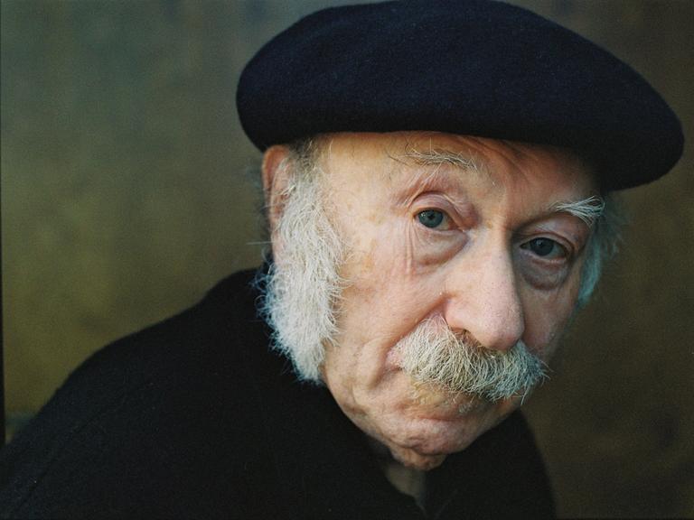 Edgar Hilsenrath schaut in die Kamera. Er hat einen weißen Schnauzer und trägt eine schwarze Baskenmütze.