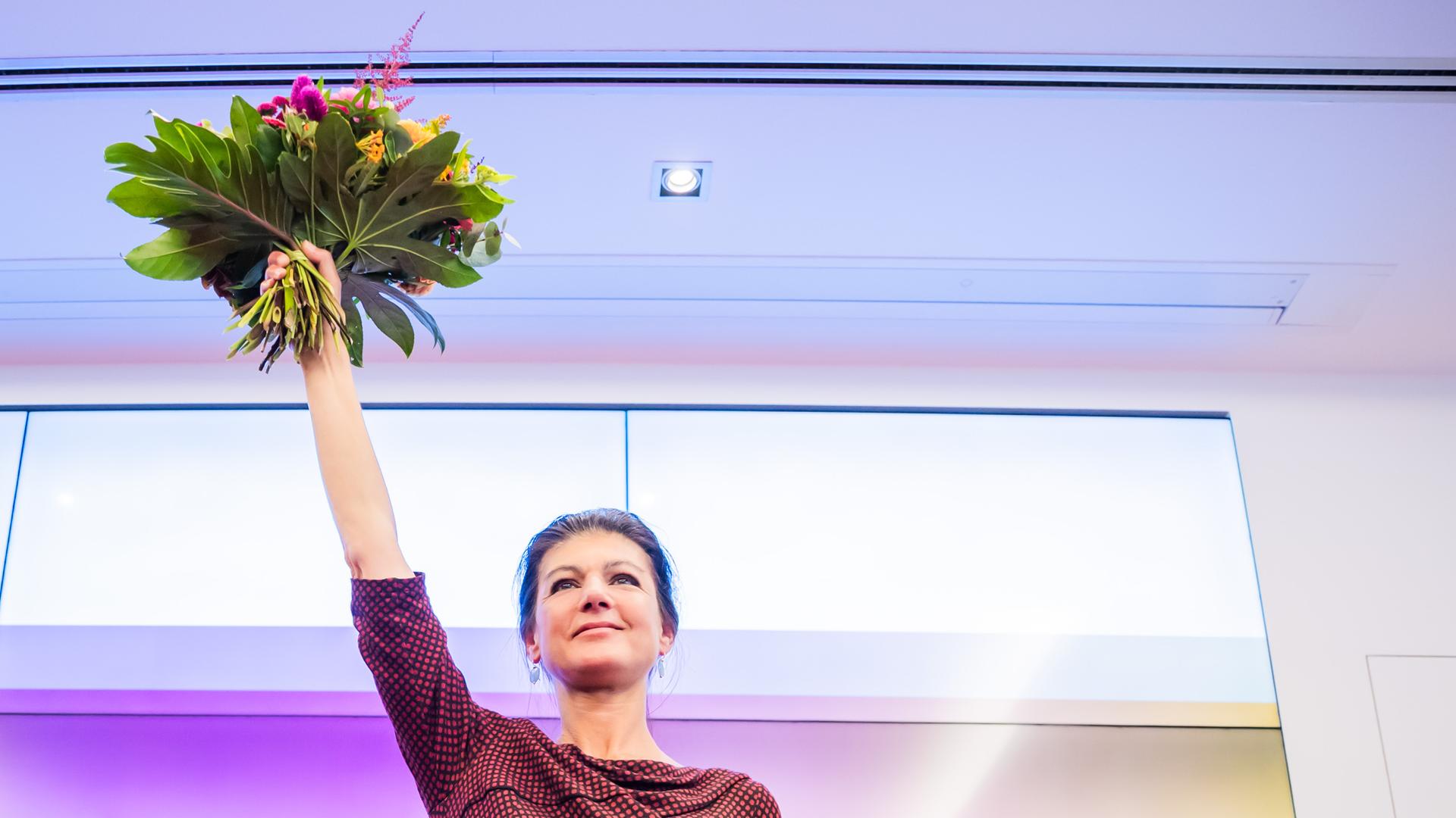 Sahra Wagenknecht, Parteivorsitzende des Bündnis Sahra Wagenknecht (BSW), hält bei der Wahlparty einen Blumenstrauß hoch. 