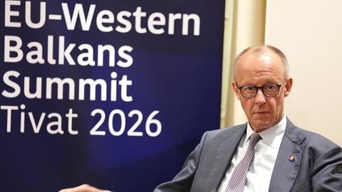 Tivat: Bundeskanzler Friedrich Merz (CDU) sitzt vor einem Wand mit der Aufschrift "EU-Western Balkans Summit Tivat 2026".