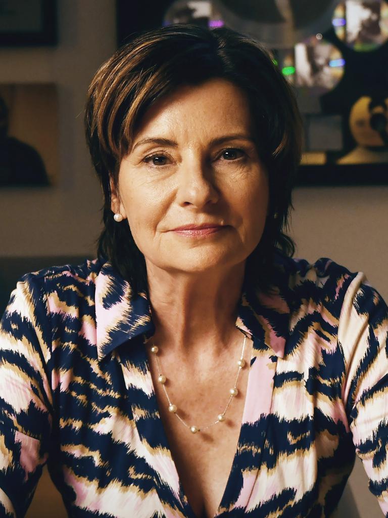 Eva Ries sitzt vor einer Wand mit gerahmten Bilder, trägt eine schwarz-weiße Bluse und schaut direkt in die Kamera. Eva Ries sitzt vor einer Wand mit gerahmten Bilder, trägt eine schwarz-weiße Bluse und schaut direkt in die Kamera.