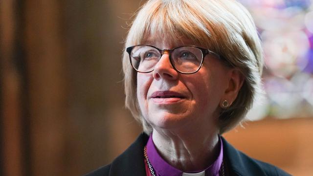Porträt-Aufnahme von Sarah Mullally vor Kirchen-Fenstern