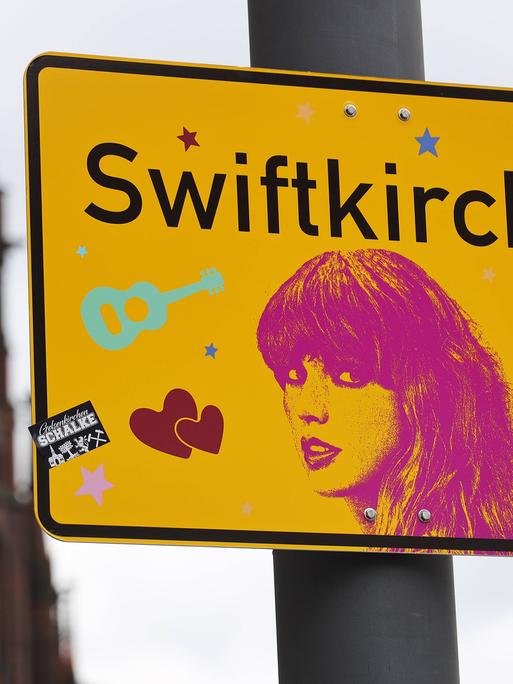 Ein Schild mit der Aufschrift Swiftkirchen statt Gelsenkirchen und einem Konterfei der Sängerin Taylor Swift, die im Juli drei Konzerte in der Arena auf Schalke gibt.