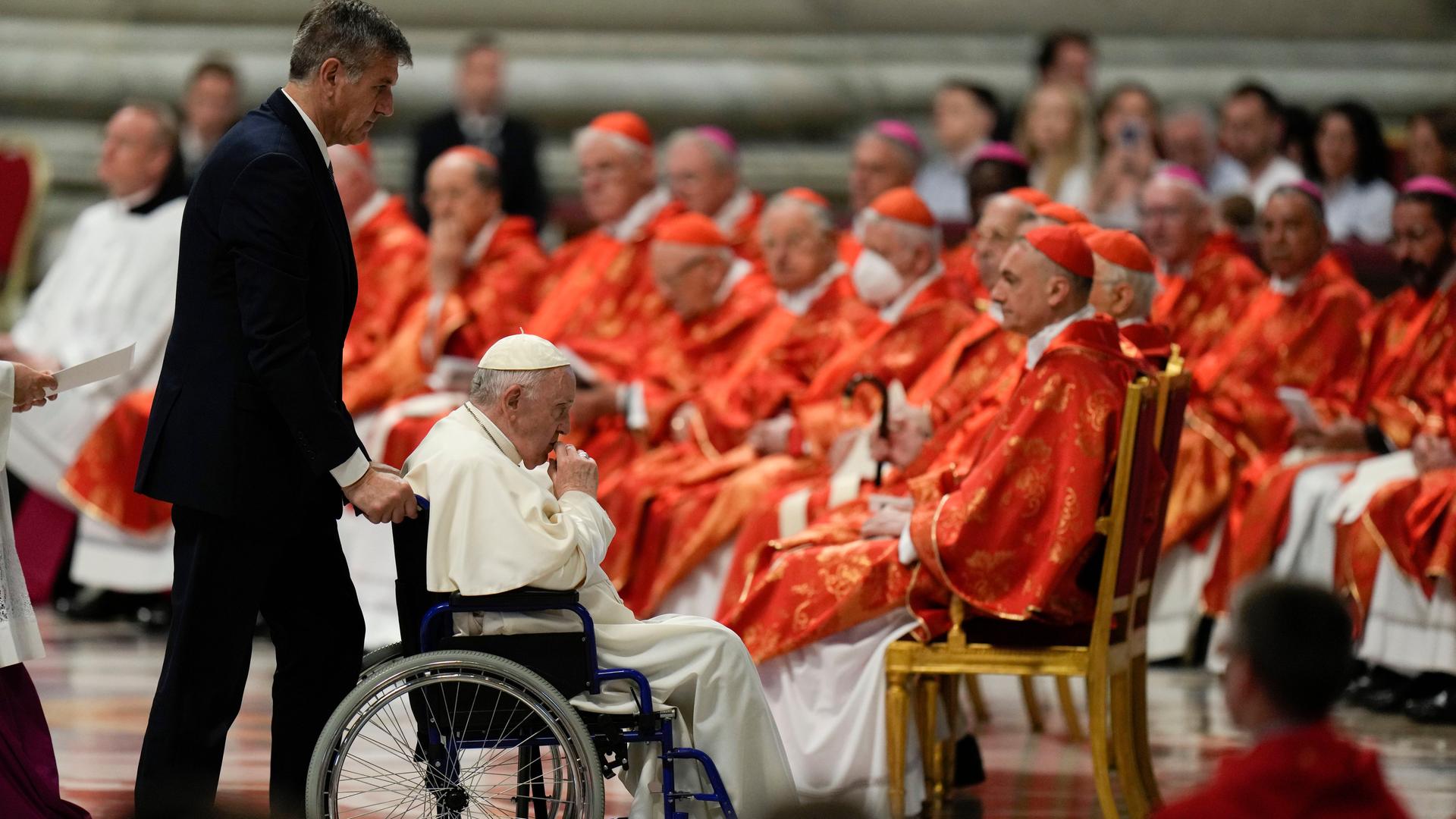 Der päpstliche Kammerdiener Sandro Mariotti schiebt Papst Franziskus in einem Rollstuhl, nachdem er die Predigt zur Pfingsmesse im Petersdom gesprochen hat. Der päpstliche Kammerdiener Sandro Mariotti schiebt Papst Franziskus in einem Rollstuhl, nachdem er die Predigt zur Pfingsmesse im Petersdom gesprochen hat.