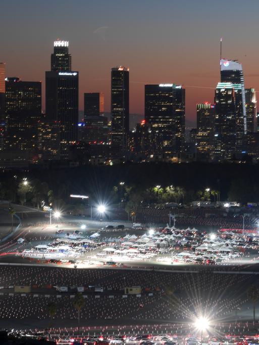 Autofahrer bilden eine Schlange vor einem Impfzentrum unter freiem Himmel im nächtlichen Los Angeles.