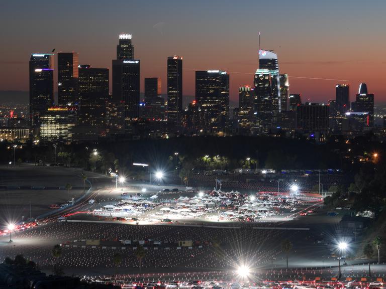 Autofahrer bilden eine Schlange vor einem Impfzentrum unter freiem Himmel im nächtlichen Los Angeles.