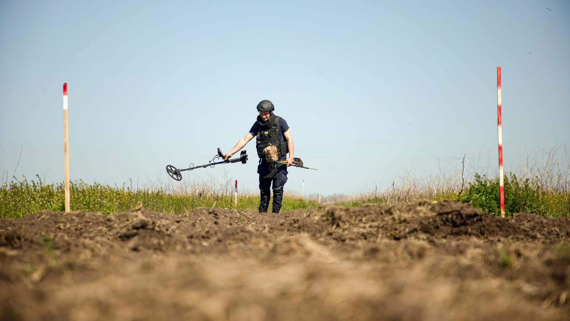 Eine Person von einem Minenräumkommando tastet den Boden während einer Minenräummission in der Region Mykolajiw (Ukraine) am 17. April 2025 mit einem Metalldetektor ab. Eine Person von einem Minenräumkommando tastet den Boden während einer Minenräummission in der Region Mykolajiw (Ukraine) am 17. April 2025 mit einem Metalldetektor ab.