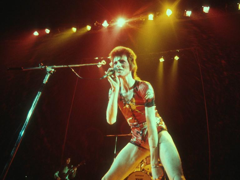 David Bowie als Ziggy Stardust im Jahr 1972 uf der Bühne mit roten Haaren.