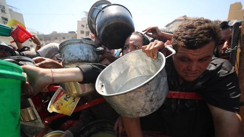 Menschen im Gazastreifen drängen sich, als eine Wohltätigkeitsorganisation warme Mahlzeiten an Palästinenser verteilt. 