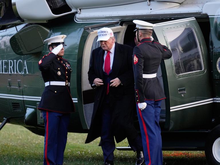 US-Präsident Donald Trump bei seiner Ankunft beim G7-Gipfel in Kananaskis, Alberta ein. Er steigt aus einem Hubschrauber und wird von zwei kanadischen Militärs begrüßt.
