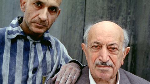 Foto zeit Simon Wiesenthal und den Schauspieler Ben Kingsley in Häfltingskleidung am Drehort des Films "Recht, nicht Rache" (Originaltitel Murderers Among Us: The Simon Wiesenthal Story), einem Filmdrama aus dem Jahr 1989, das die Lebensgeschichte des Nazijägers Simon Wiesenthal erzählt.