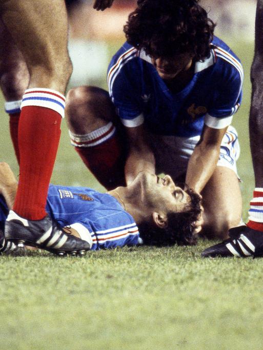 Der Franzose Patrick Battiston liegt nach dem Foul durch Toni Schumacher im WM-Halbfinale 1982 gegen Deutschland auf dem Boden.
