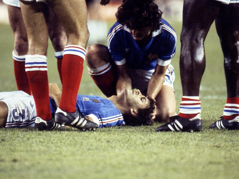 Der Franzose Patrick Battiston liegt nach dem Foul durch Toni Schumacher im WM-Halbfinale 1982 gegen Deutschland auf dem Boden.