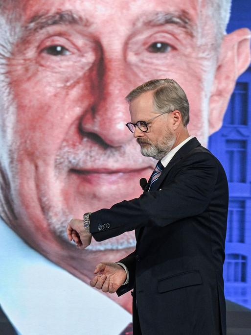 Andrej Babis und Petr Fiala stehen bei einer TV-Wahlkampfveranstaltung vor einem Studiohintergrund mit einem riesigen Porträt von Andrej Babis. Andrej Babis und Petr Fiala stehen bei einer TV-Wahlkampfveranstaltung vor einem Studiohintergrund mit einem riesigen Porträt von Andrej Babis.