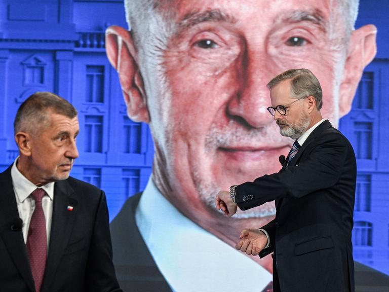 Andrej Babis und Petr Fiala stehen bei einer TV-Wahlkampfveranstaltung vor einem Studiohintergrund mit einem riesigen Porträt von Andrej Babis. Andrej Babis und Petr Fiala stehen bei einer TV-Wahlkampfveranstaltung vor einem Studiohintergrund mit einem riesigen Porträt von Andrej Babis.