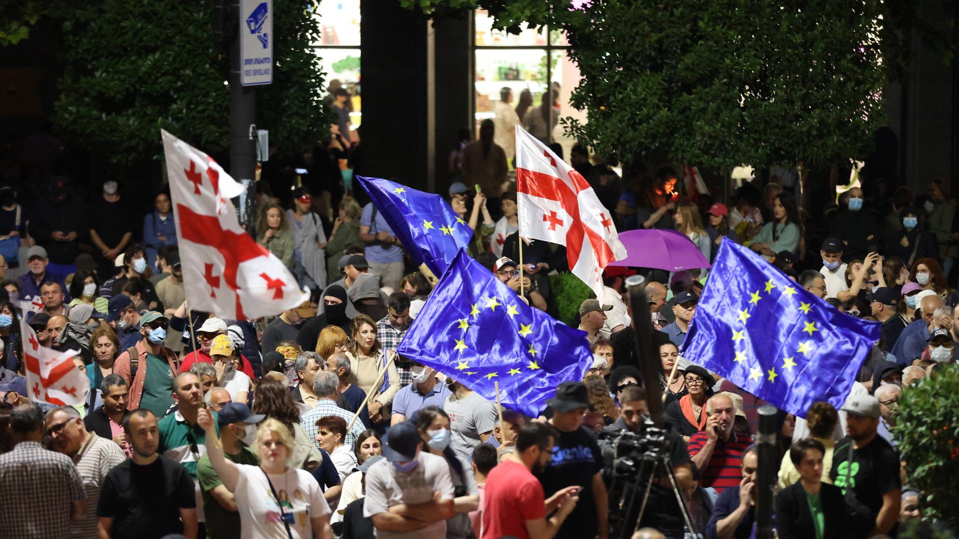Demonstrierende schwenken vor dem Parlament in Tiflis europäische und georgische Fahnen. Demonstrierende schwenken vor dem Parlament in Tiflis europäische und georgische Fahnen.