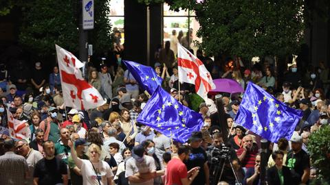 Demonstrierende schwenken vor dem Parlament in Tiflis europäische und georgische Fahnen.