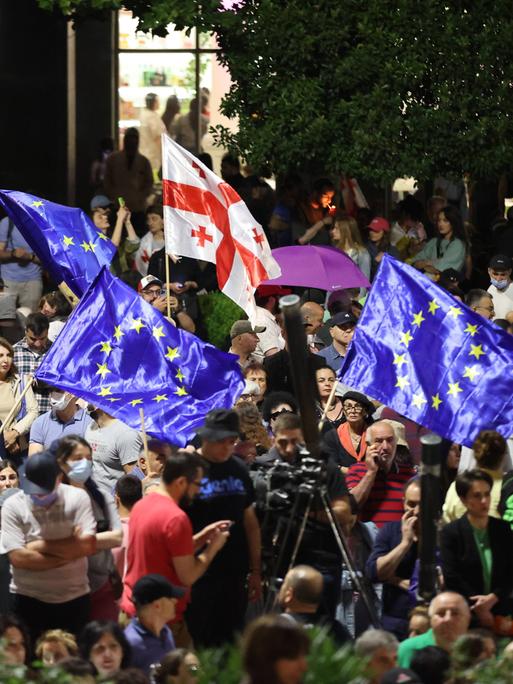Demonstrierende schwenken vor dem Parlament in Tiflis europäische und georgische Fahnen.