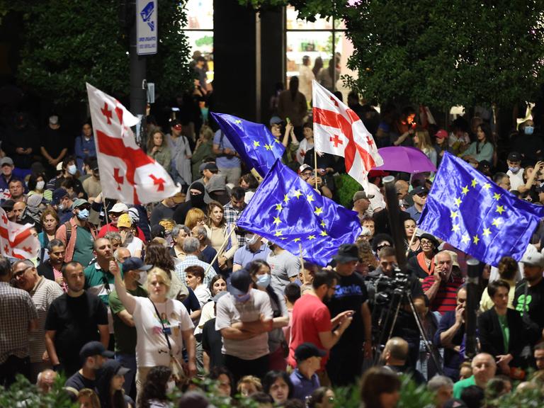 Demonstrierende schwenken vor dem Parlament in Tiflis europäische und georgische Fahnen.