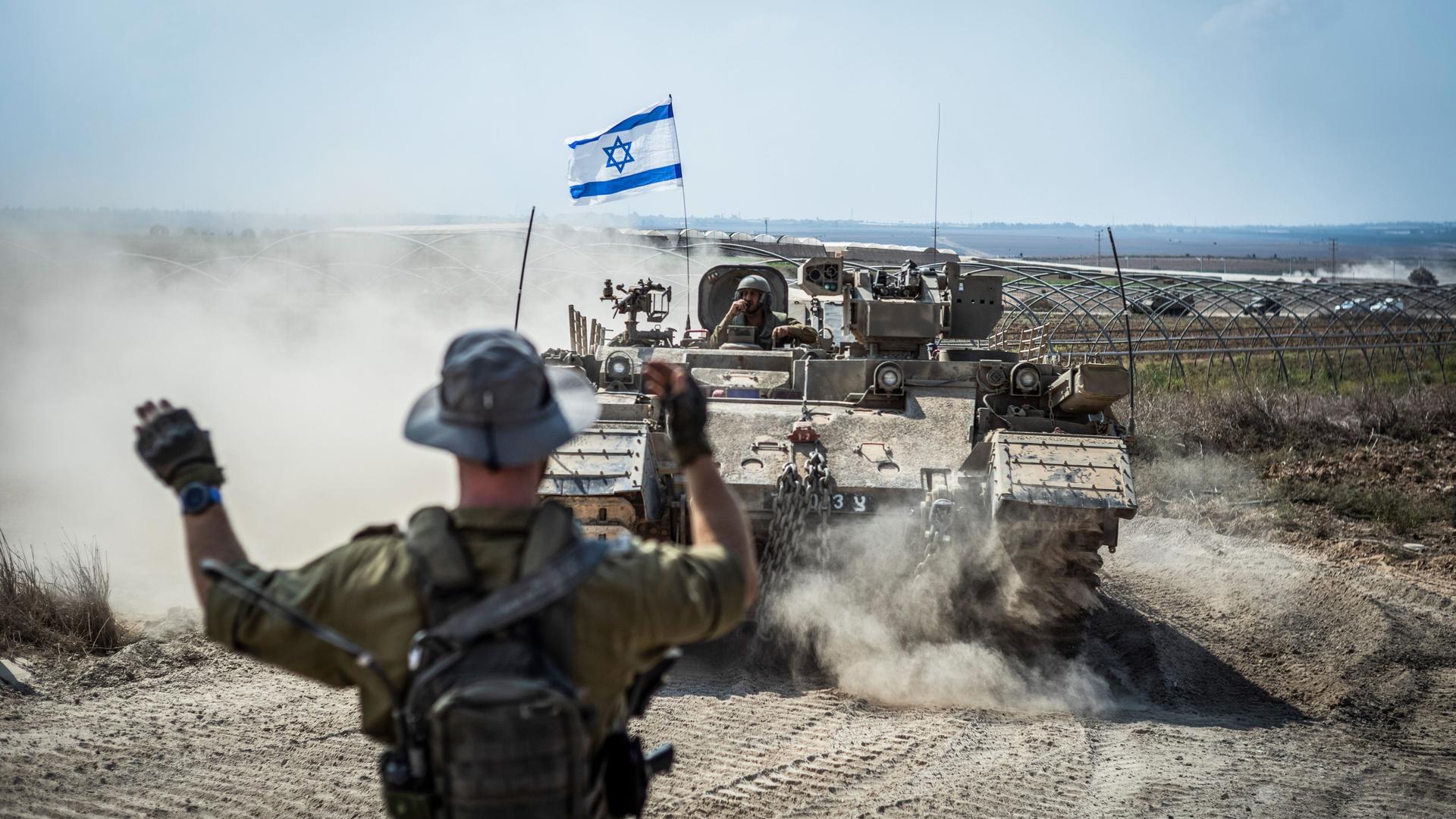Mehrere israelische Kampffahrzeuge und Panzer sind in der Nähe der Grenze zwischen Israel und Gaza im Einsatz. 