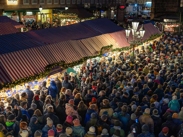 Das Foto zeigt dicht gedrängte Menschen am Eröffnungstag des Christkindlesmarktes in Nürnberg. 