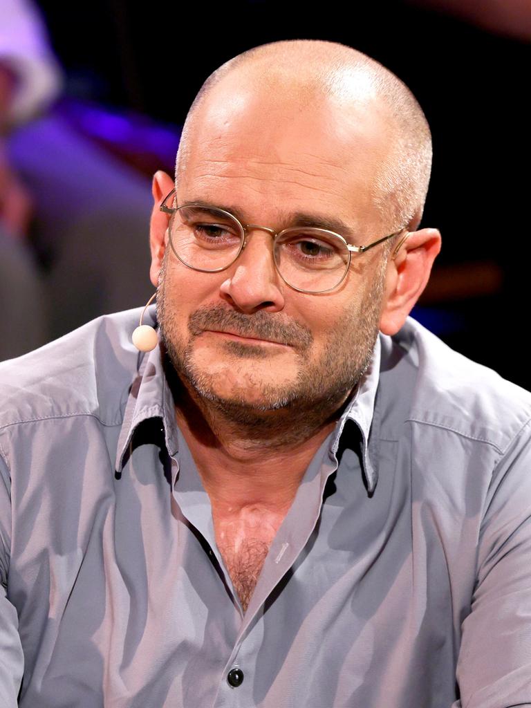 Das Foto zeigt Jonas Lüscher vom Oberkörper aufwärts. Er trägt ein graues Hemd, dessen oberster Knopf geöffnet ist. 