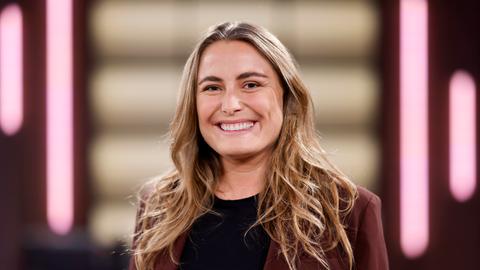 Nathalie Pohl steht in einem Fernsehstudio und lacht in die Kamera Nathalie Pohl steht in einem Fernsehstudio und lacht in die Kamera