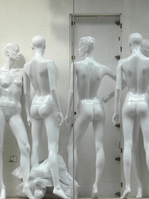 Umbau eines Bekleidungsgeschäftes. Schaufenster mit unvollständig zusammengebauten unbekleideten Schaufensterpuppen.