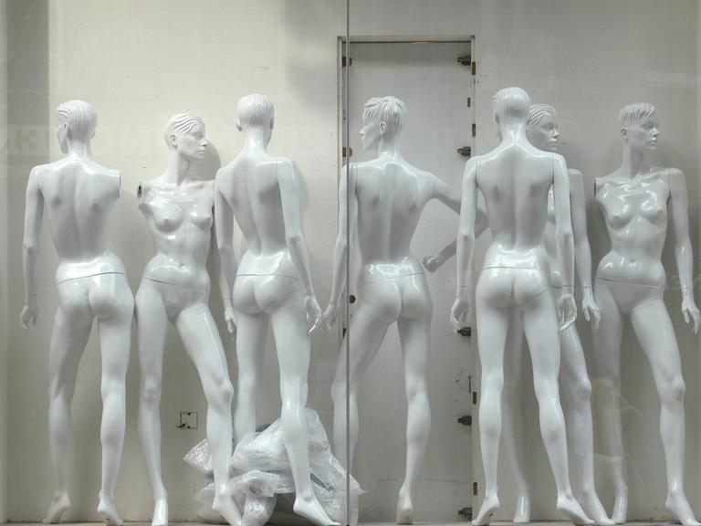 Umbau eines Bekleidungsgeschäftes. Schaufenster mit unvollständig zusammengebauten unbekleideten Schaufensterpuppen.