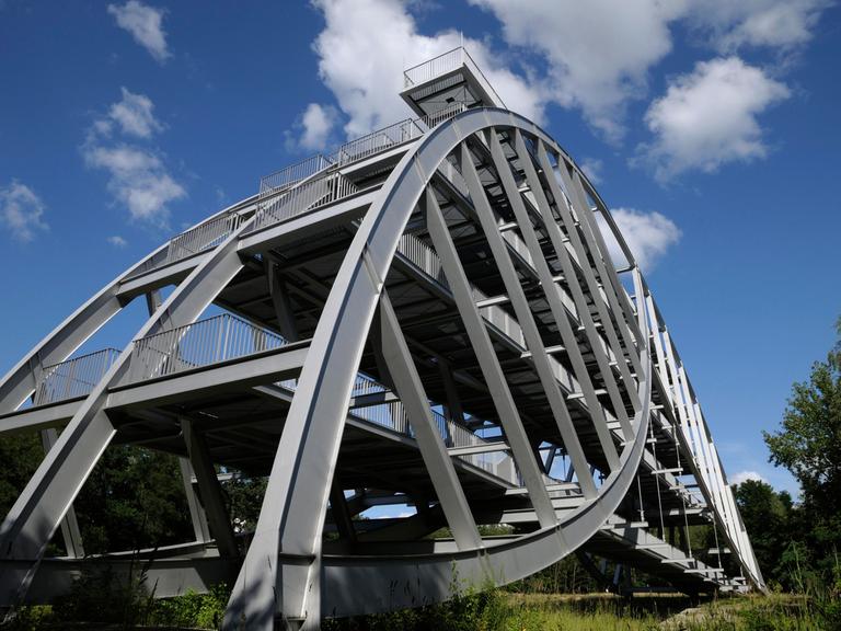 Auf dem Bitterfelder Berg erhebt sich eine schwungvolle stählerne Bogenkonstruktion, die an Brückenarchitektur erinnert