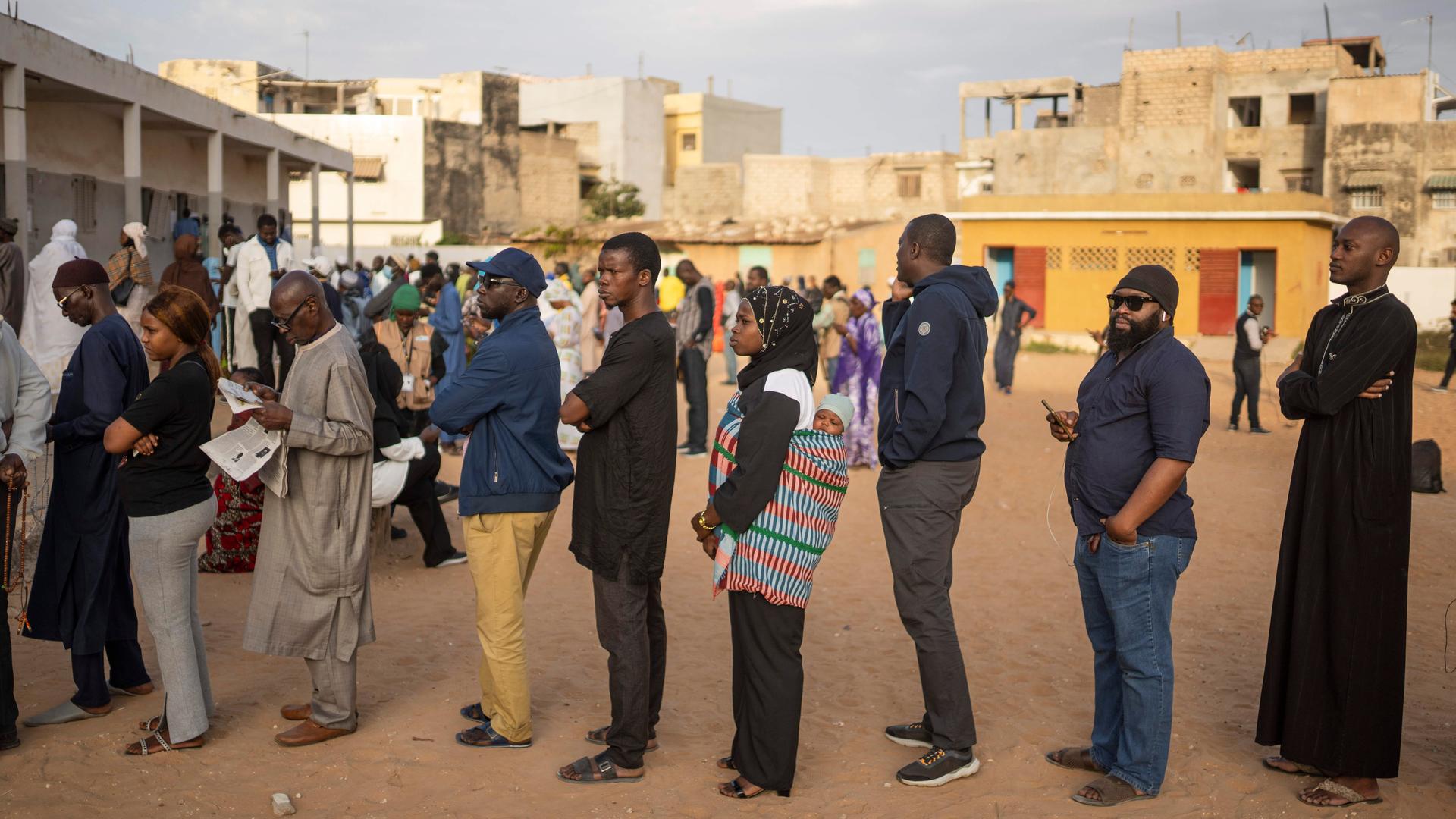 Menschen warten vor einem Wahllokal in Senegal auf die Abgabe ihrer Stimme.