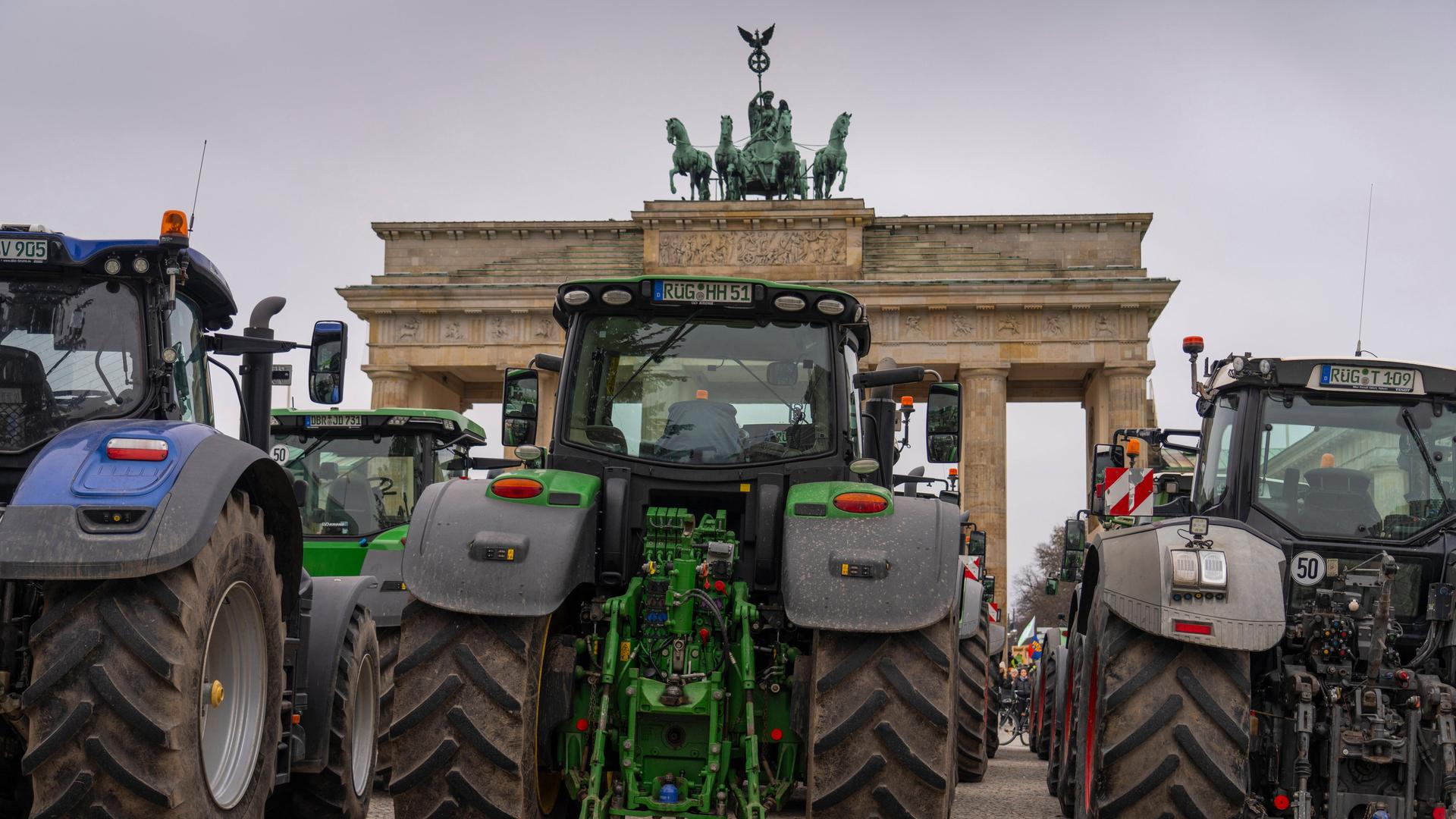 Traktoren stehen aus Protest von deutschen Bauen am 18. Dezember 2023 vor dem Brandenburg Tor in Berlin.