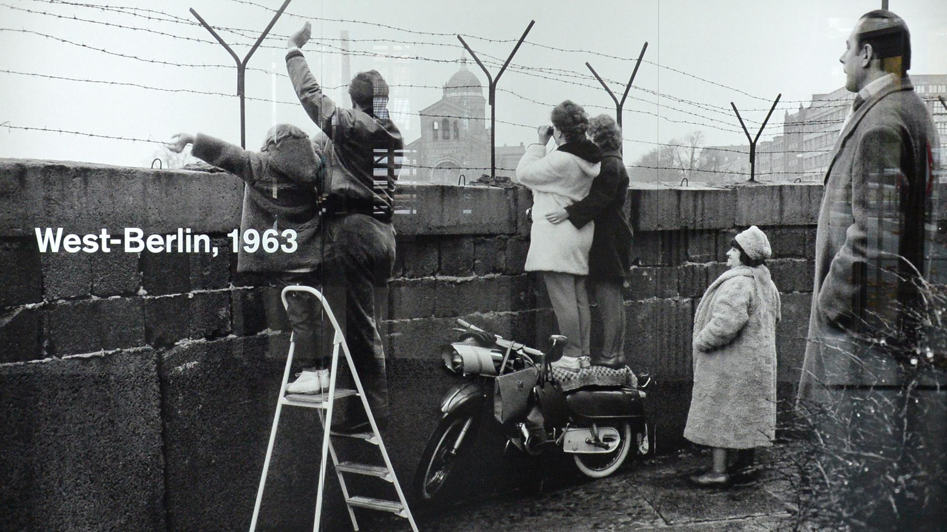 Das Foto zeigt den Versuch der Kontaktaufnahme auf der Westberliner Seite der Mauer am Leuschnerdamm (1963).