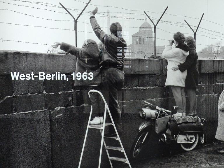 Das Foto zeigt den Versuch der Kontaktaufnahme auf der Westberliner Seite der Mauer am Leuschnerdamm (1963).