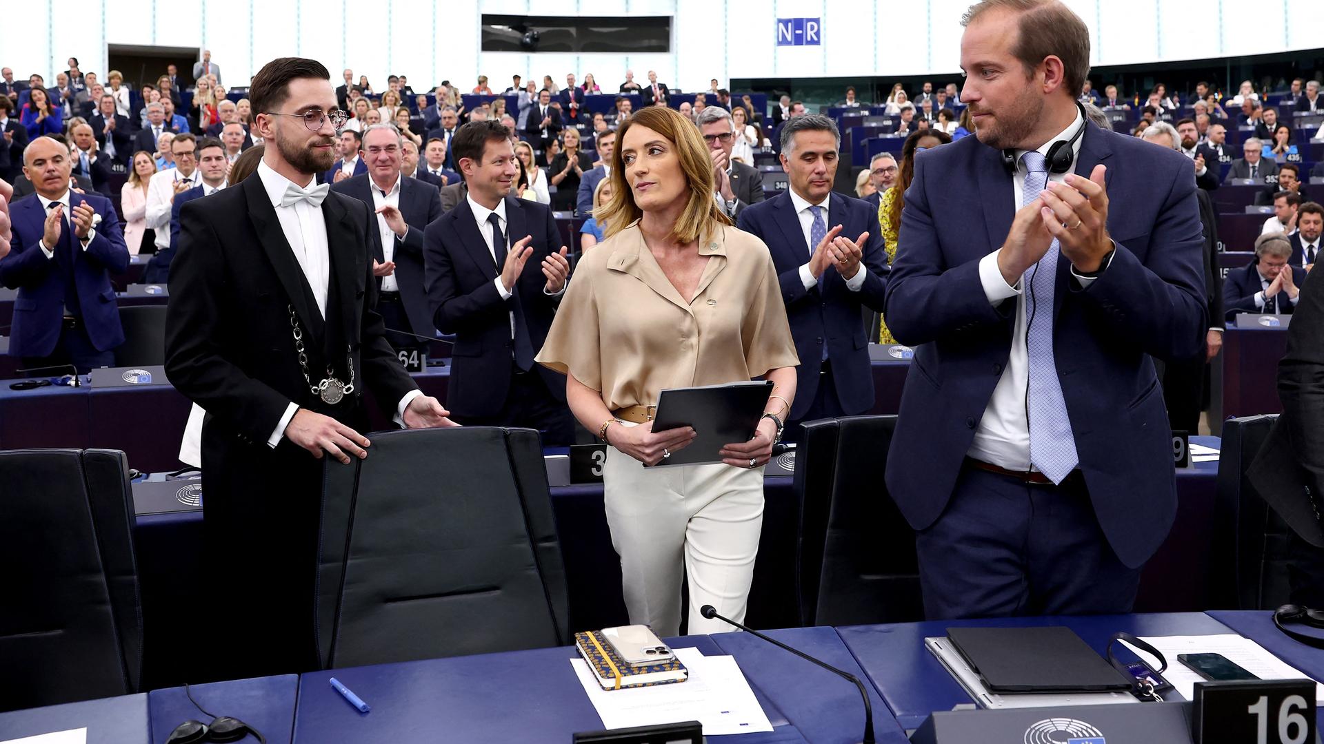 Die Abgeordneten im Parlament applaudieren Roberta Metsola. Sie hält eine Akte in den Händen. Die Abgeordneten im Parlament applaudieren Roberta Metsola. Sie hält eine Akte in den Händen.