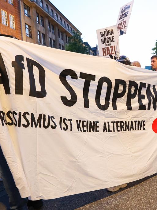 Teilnehmer einer Demonstration gegen Rechts halten ein Banner mit der Aufschrift "AfD stoppen! Rassismus ist keine Alternative".