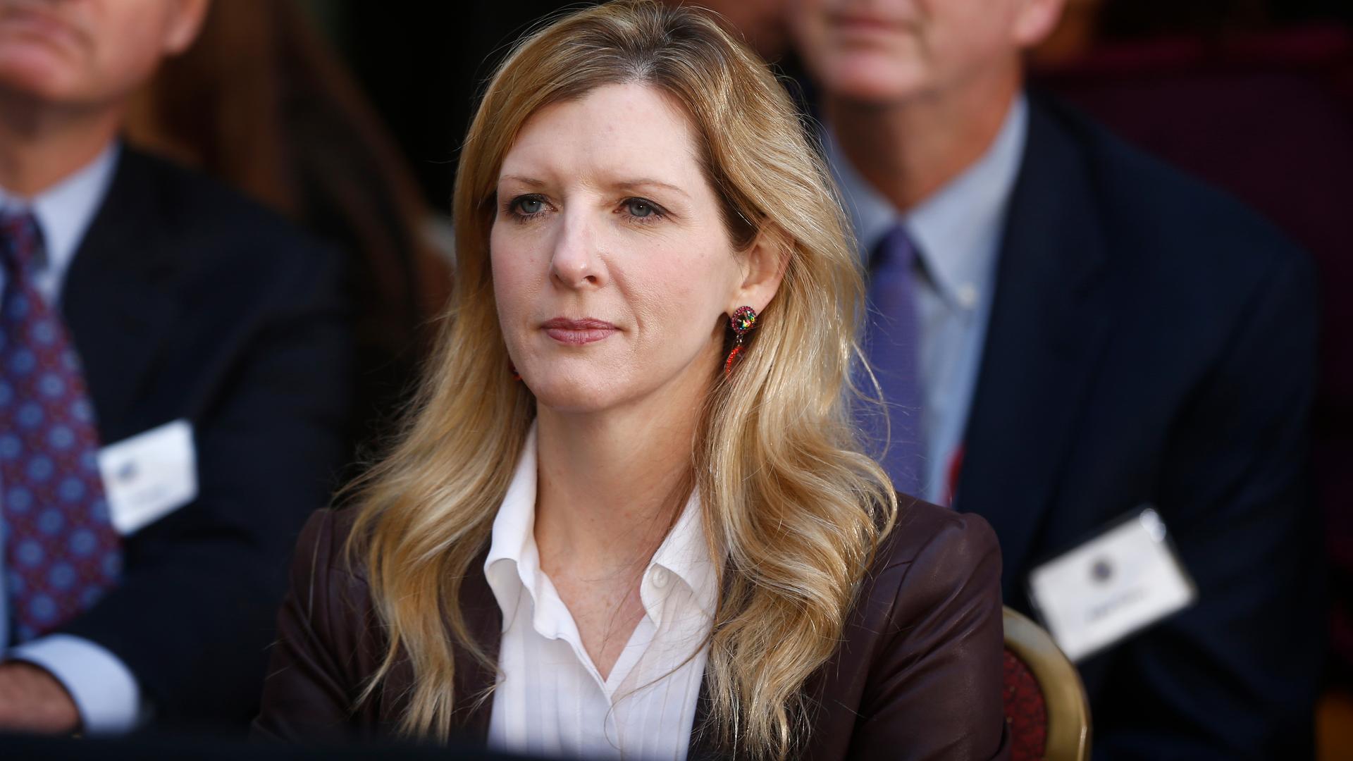 Kathryn Ruemmler im Porträt, hinter ihr noch zwei verschwommene Personen.