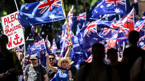 Demonstranten halten die australische Flagge hoch.